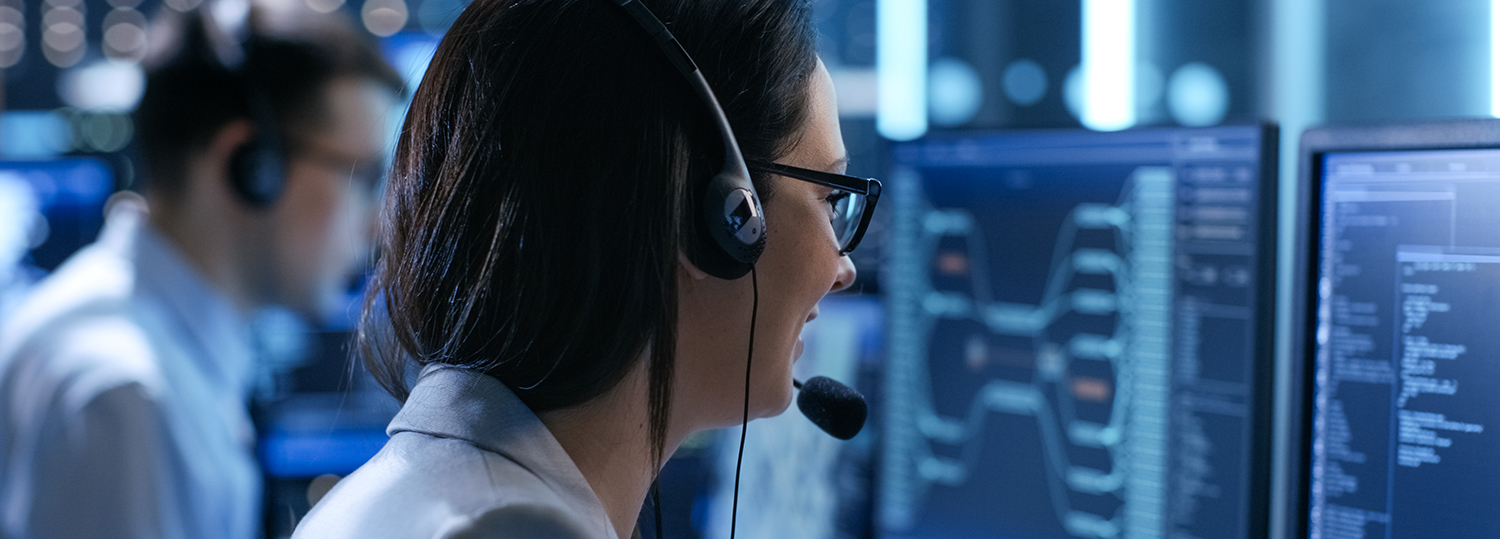 In het System Control Center geeft de vrouw die in een technisch ondersteuningsteam werkt instructies met behulp van de headsets.